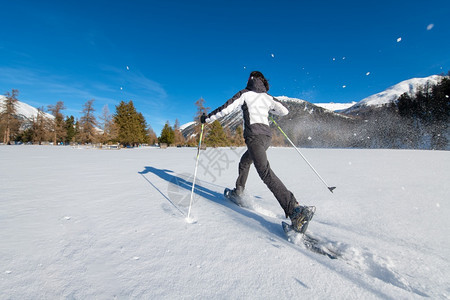 极端充满活力的雪鞋漫步在一片大积雪中山广阔图片