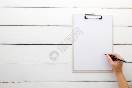 图表夹子在白色剪贴板上手持笔在旧的白木背景模板版上用空白纸打印卡片图片