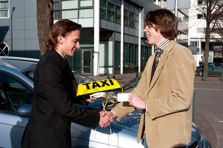 一名官员边握手向新任命的出租车司机递上牌照并签字一种保持白人图片