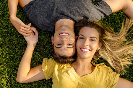 幸福躺在草地上的一对年轻美夫妇的肖像季节美丽图片