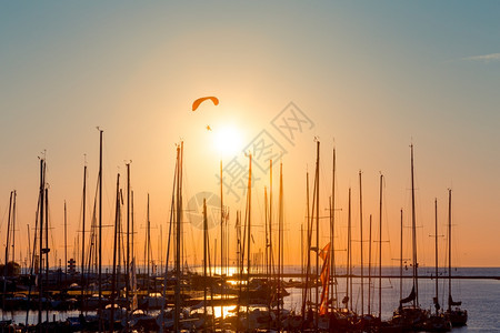 日落在游艇双轮和太阳海上滑翔伞降落机图片