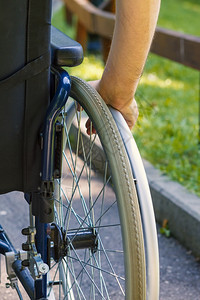 青年男子在城市公园轮椅上手牵青年男子在轮车上手握美丽的残疾人太阳图片