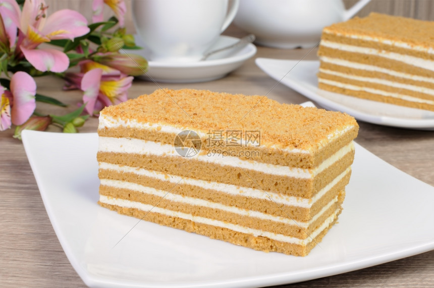 装饰风格蜜糖糕点一小块蜂蜜蛋糕一杯咖啡和朵花放在桌上图片