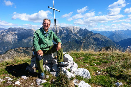 步行坐在山顶微笑和看镜头的登山者最佳户外图片