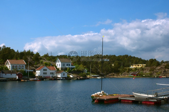 沿着挪威南部岸林戈尔村内载有帆船和白房子的喷气艇和白色房屋乡村的图片