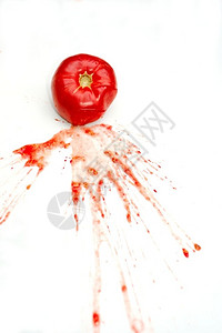 蔬菜水果健康一只闪亮的红番茄在白色背景上喷洒果汁和种子散布在孤立的土豆泥里图片