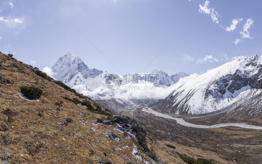 蓝天白云下的雪山峡谷风光图片