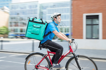 人们运动双自行车在城市中运送食品的库里尔白种人图片