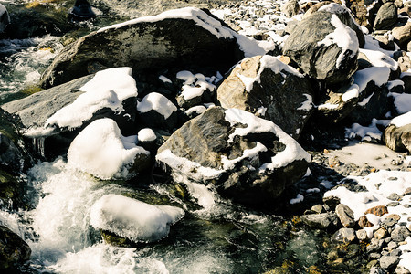 流动荒野冬季的山河冷水流在岩石之间山上游过河流冬天图片