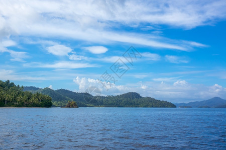 绿色旅行蓝的热带岛屿和云蓝天丛林中云热带岛屿和层的蓝色天空中云图片