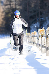 一个女孩搭乘雪鞋和电杆背包骑一种图片