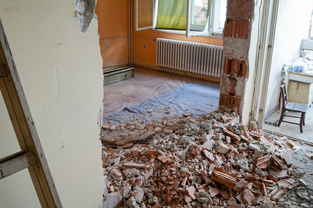 墙砸碎到公寓中的废墟室准备翻新并拆除被摧毁的碎墙进入粉损害图片