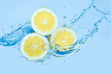 运动一种在浅蓝色背景下在柠檬片上泼水移动图片