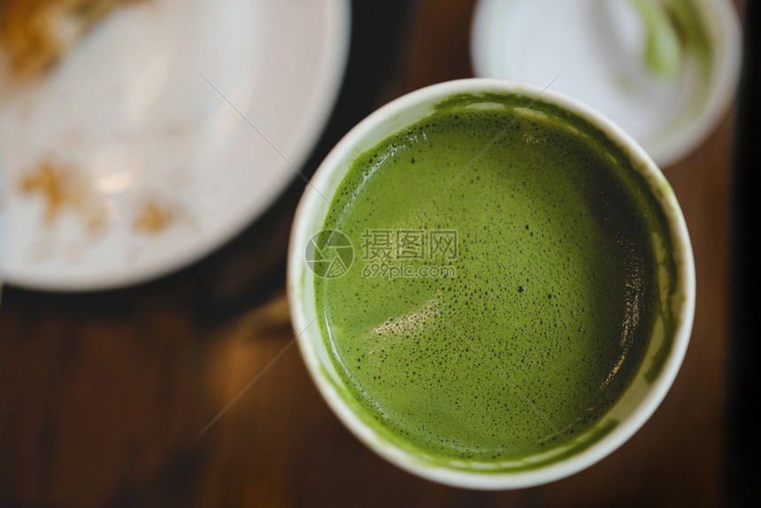 城市的早餐桌上咖啡厅或场景杯中抹茶绿拿铁的特写黑暗图片