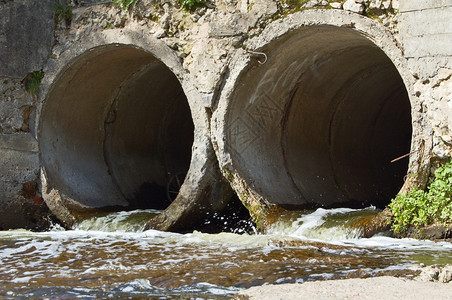 两根混凝土排水管的流出污口走沟渠背景图片