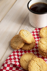 桩烘烤的土制饼干和黑咖啡杯放在白木制铁餐桌上美味的图片