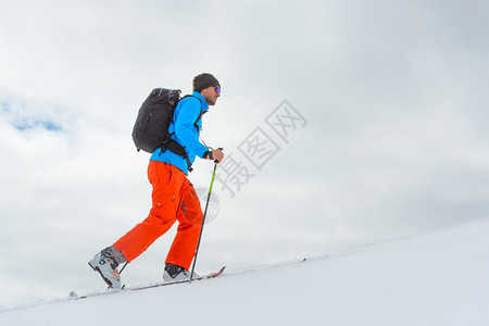 征服独自一个人滑雪的登山者爬上高峰会最佳叉图片