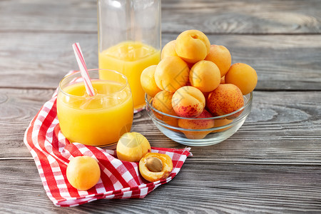 浆果奶瓶玻璃和木制桌面的杏子汁红餐巾夏天仍然活生酒杯玻璃和木制桌面的杏子汁健康自然图片