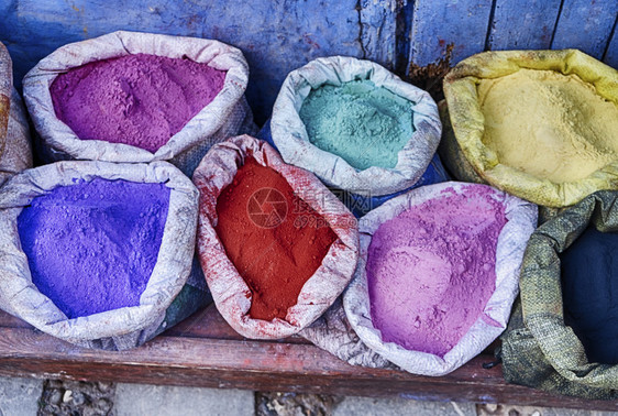 6袋装满亮彩色颜料的6袋在摩洛哥蓝城厨师店外站立紫色的画店铺图片