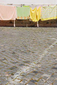 典型的里斯本风景与衣服干燥在人行道上脚下石棺泥路面窗户墙优质的图片