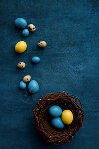 美丽的在蓝布底Paschal食物活动装饰春季假日庆祝活动标志和蓝底装饰蜂巢中的复活节鸡蛋装饰蜂巢的复活节鸡蛋象征庆典图片
