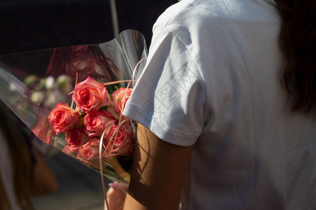 一种女人手上握着一束红玫瑰的花绿色周年纪念日图片