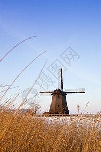 刀欧洲的著名冬季风车有雪和蓝天空图片