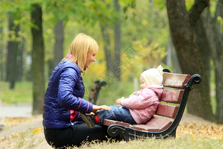 家女母亲与儿一起在公园玩耍母亲与她的女儿一起坐在公园的椅子上玩耍妈图片