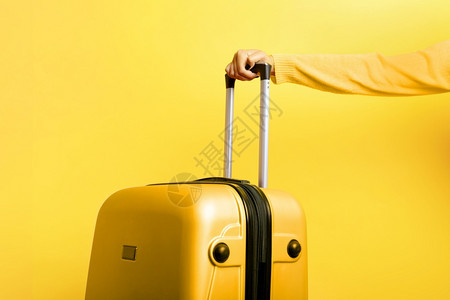 商业保持妇女有黄色手提箱持黄色背景旅行概念等黄色背景包图片