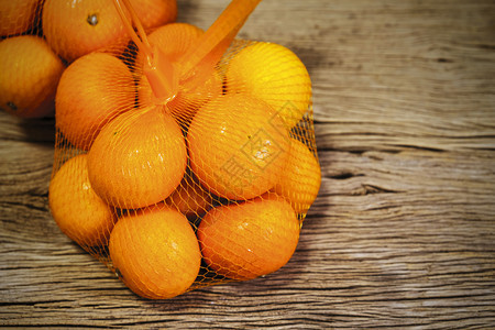 橙生的皮肤以木本背景和复制空间包装的普通柑橘图片