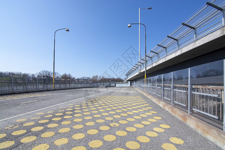 点缀下一个过境在瑞典斯德哥尔摩的汽车路线旁边宽人行桥上的黄点在宽人行桥上的黄色点图片