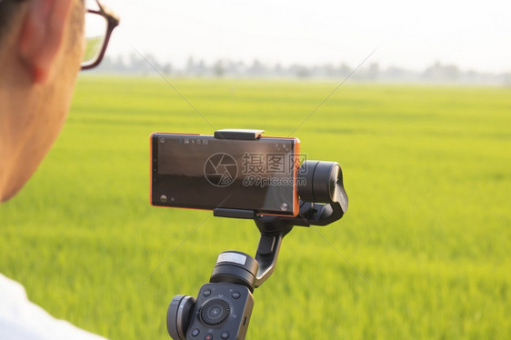 电话摄影师数字的泰国TakTak泰国20年3月日手机正在拍摄一部影片使用GimbalZhiyunSluly4田间米图片