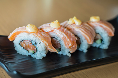 海藻灰鲑鱼寿司卷黑陶瓷盘上的日本食品风格新鲜的传统图片