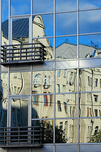 现代的住房商业建筑以其窗户反映旧公寓楼的宇图片