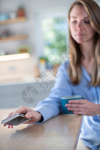 三十岁瘾家关注过度使用社会媒体将移动电话停放在桌面上的妇女问题ACN9WGIIIWP8图片