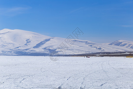 下雪的海冰冻湖泊和山上风景在雪中天图片