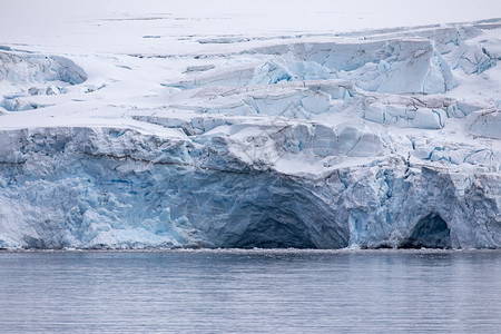 落下白色的水南极洲带蓝色金库和冰洞的川图片