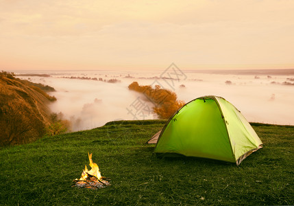 武汉东湖绿道假期沿河上山顶的绿色旅游帐篷上面有晨雾沿河上山边的绿色旅游帐篷上面有早雾覆盖野营背景