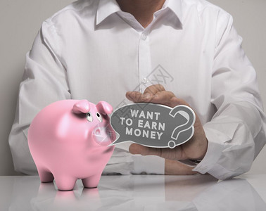 获得现金一张男子手持语音气球和文字的图象希望赚取金钱粉红小猪银行白衬衫挣钱概念金融背景图片