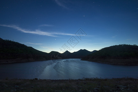 黄色的夜晚星体光中闪耀的天空与山和湖风景图片