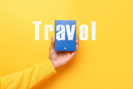 蓝色护照携带黄背景世界旅行概念和蓝色的游黄图片