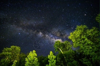 泰国星系夜间天空的一部分在赤道纬度上有恒星和银河下面有绿色热带树闪电图片