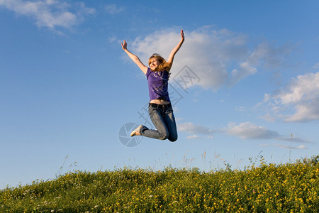女孩们在绿草地上跳跃的女孩成功杂技演员图片