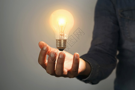 新的聪明有创造力拥室内灯泡人手握着房间里灯泡这能节约电力图片