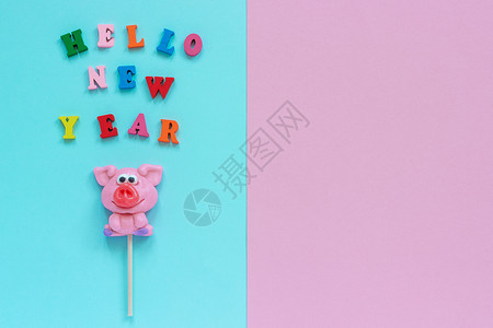 有趣的粉红猪棒糖和多彩标志你好新年在蓝粉红背景的新年最佳视野复制空间布局概念贺卡猪棒糖年文本哈罗新题词小猪问候图片