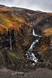 一种溪流冰岛东边的海尼福斯和伊利特兰弗瀑布在冰河中阴云笼罩的一天里冰岛坠落图片