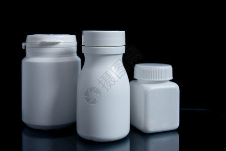 药片抗生素黑色背景的白药瓶医学概念黑本底的白药瓶包裹图片