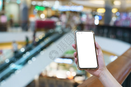 女士内部的Mockup双手在模糊的百货商店拿着空白屏幕移动电话数字付款概念电子手机图片