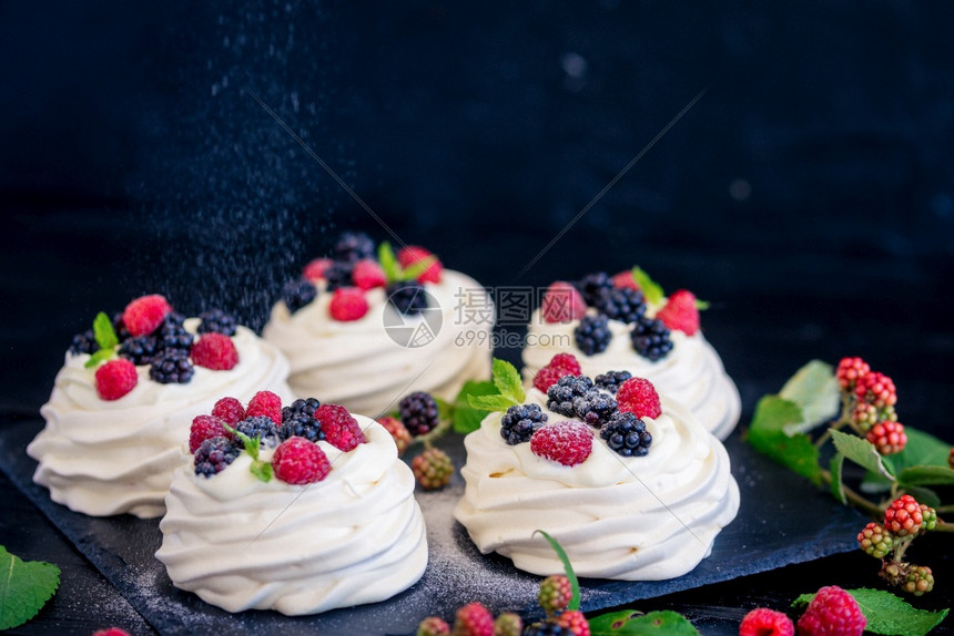 帕夫洛娃俄国常用女名自制蛋白甜饼基础新鲜蓝莓和黑色混凝土纹理背景上的糖粉对待派图片