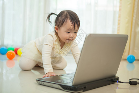 婴儿小亚洲女孩在家里玩笔记本电脑的肖像孩子喜悦图片